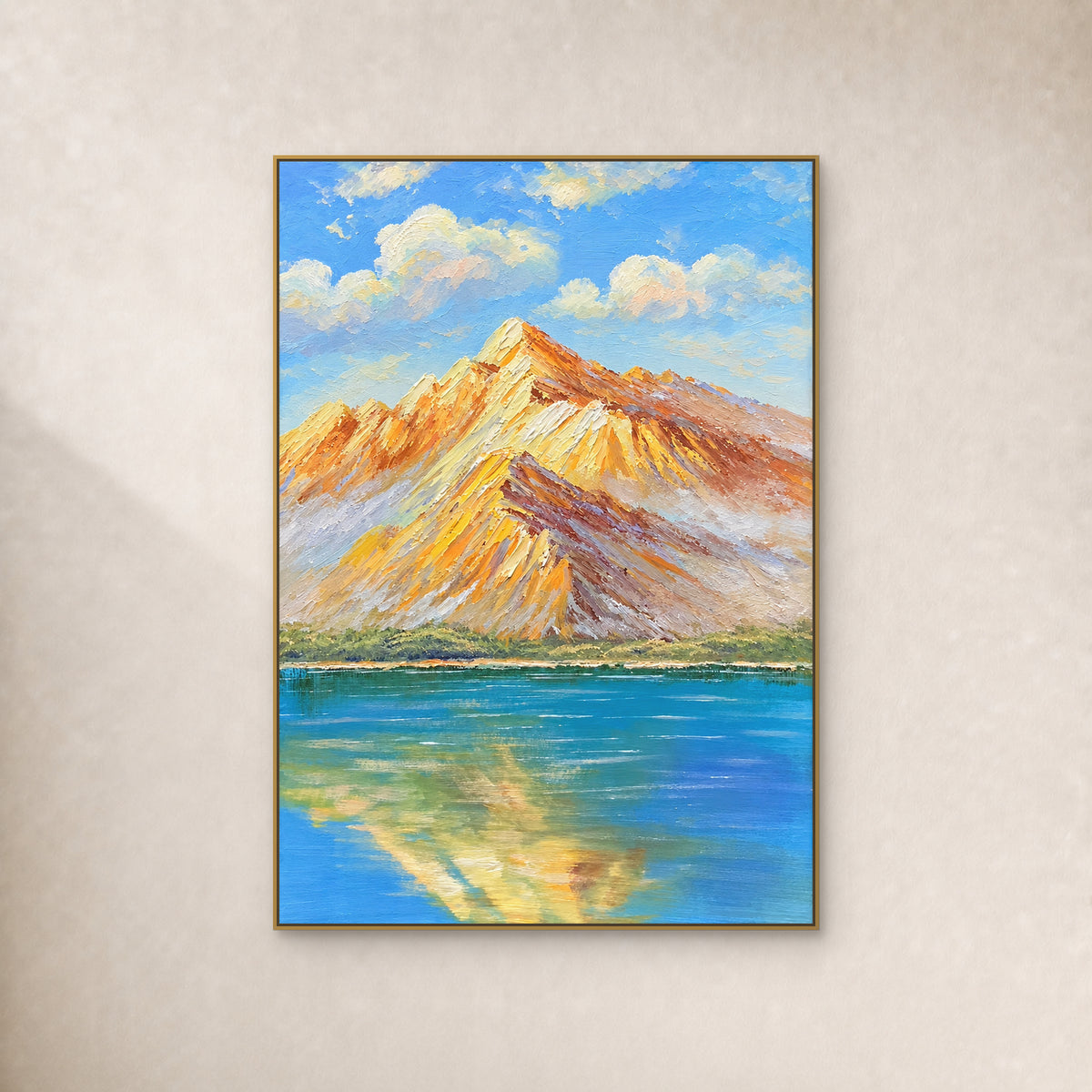 Amber mountain ridges and their blue-lake reflection in a thin gold-tone floating frame on an ivory wall