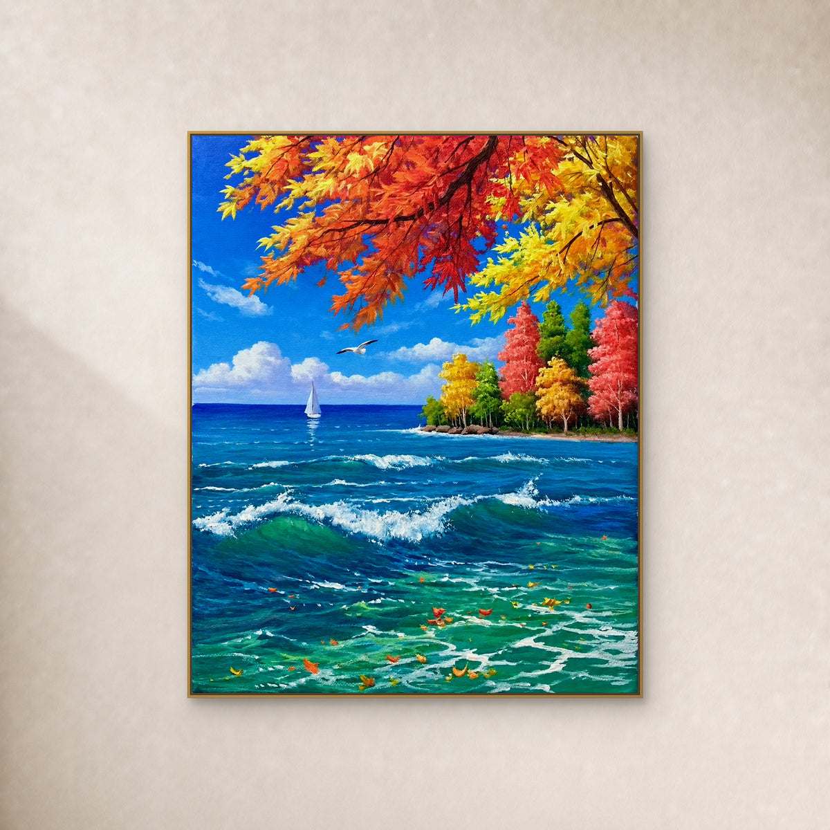 Autumn leaves over turquoise waves, a white sail and a wooded headland in a thin gold-tone frame on an ivory wall