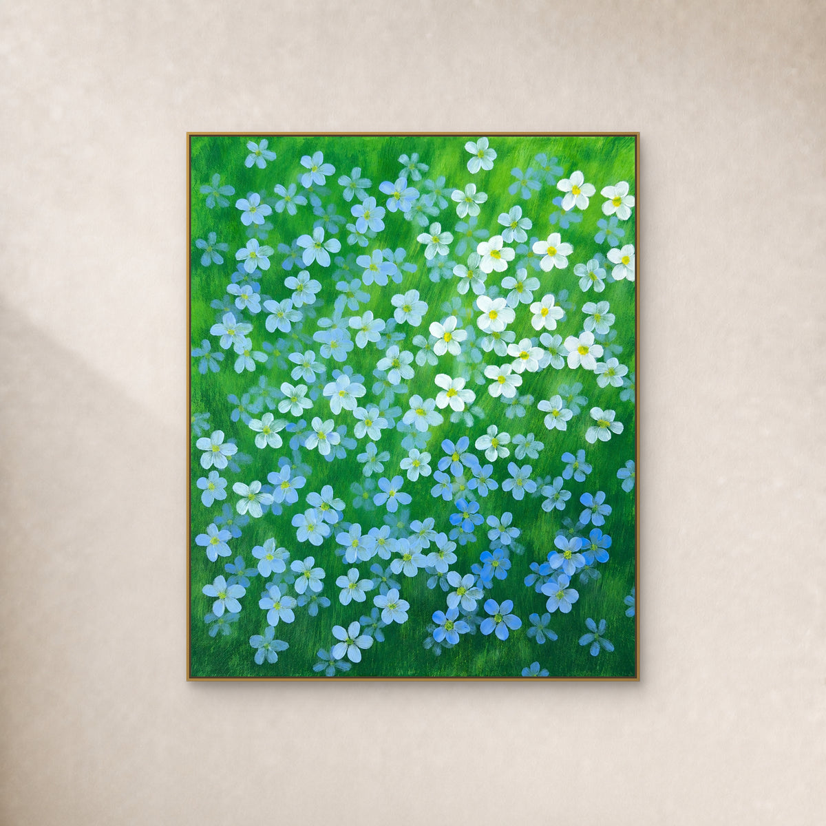 Blue and white flax flowers on green in a thin gold floating frame against an ivory wall
