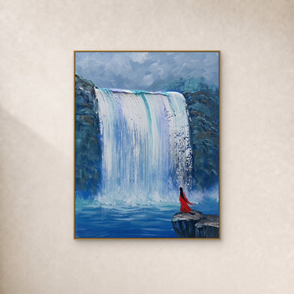 White waterfall between blue cliffs and a small red-cloaked figure, in a slim gold frame on an ivory wall.
