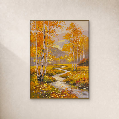 Golden birch trees and a winding stream in a slim gold frame on an ivory wall