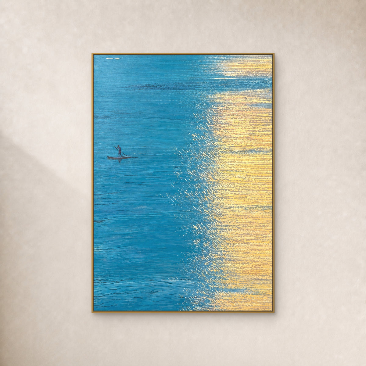 Turquoise water and a small boat beside golden reflections, in a slim gold floating frame on an ivory wall