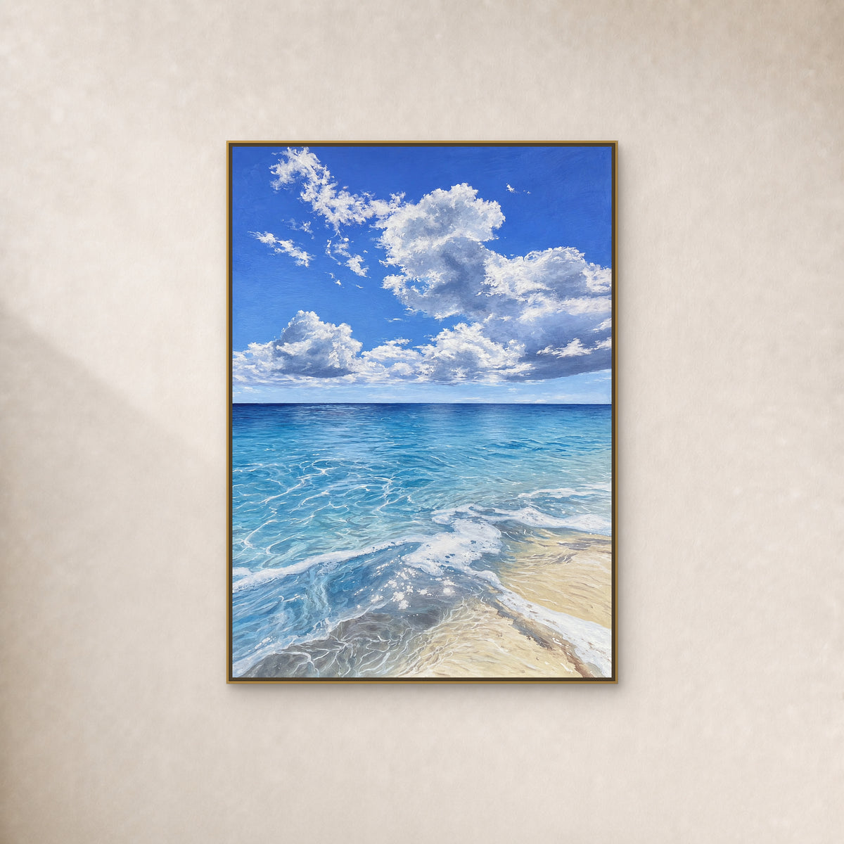 Blue ocean and curling white clouds in a thin gold-tone floating frame on a continuous ivory wall