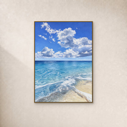 Blue ocean and curling white clouds in a thin gold-tone floating frame on a continuous ivory wall