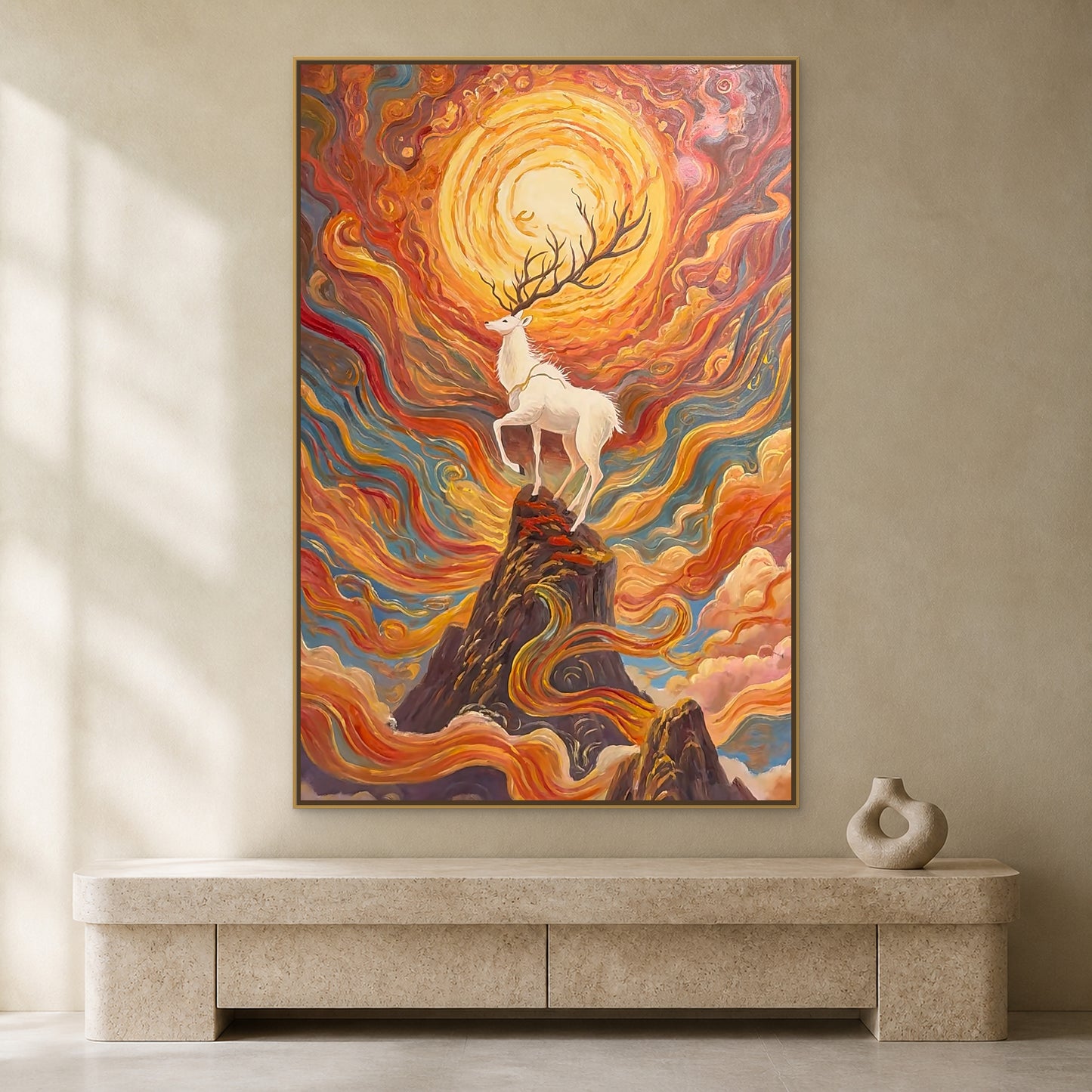 White deer and radiant sunrise mountain painting in a thin gold floating frame on a warm ivory wall