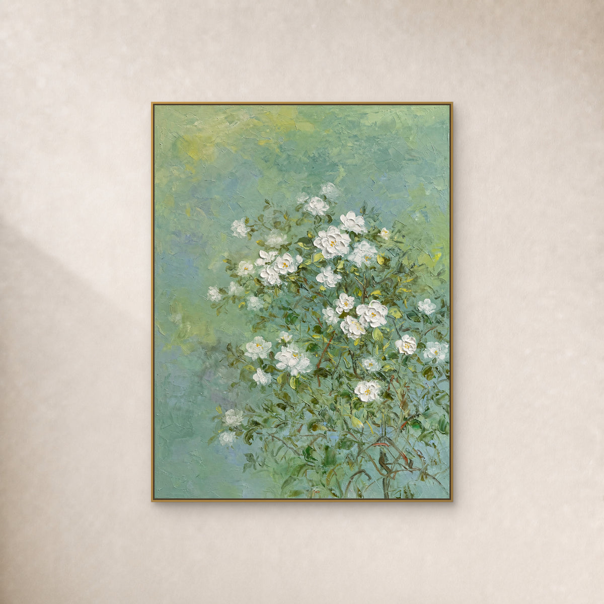White jasmine painting on a soft green field in a slim gold floating frame against an ivory wall