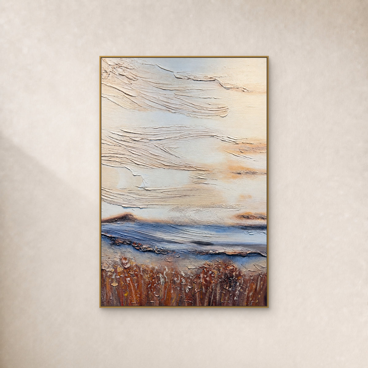Ivory textured abstract painting with a low blue band and rust-brown base, in a thin gold frame on an ivory wall