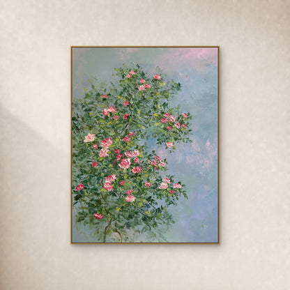 Vertical pink rose and green foliage painting in a thin gold-tone floating frame on a warm ivory wall