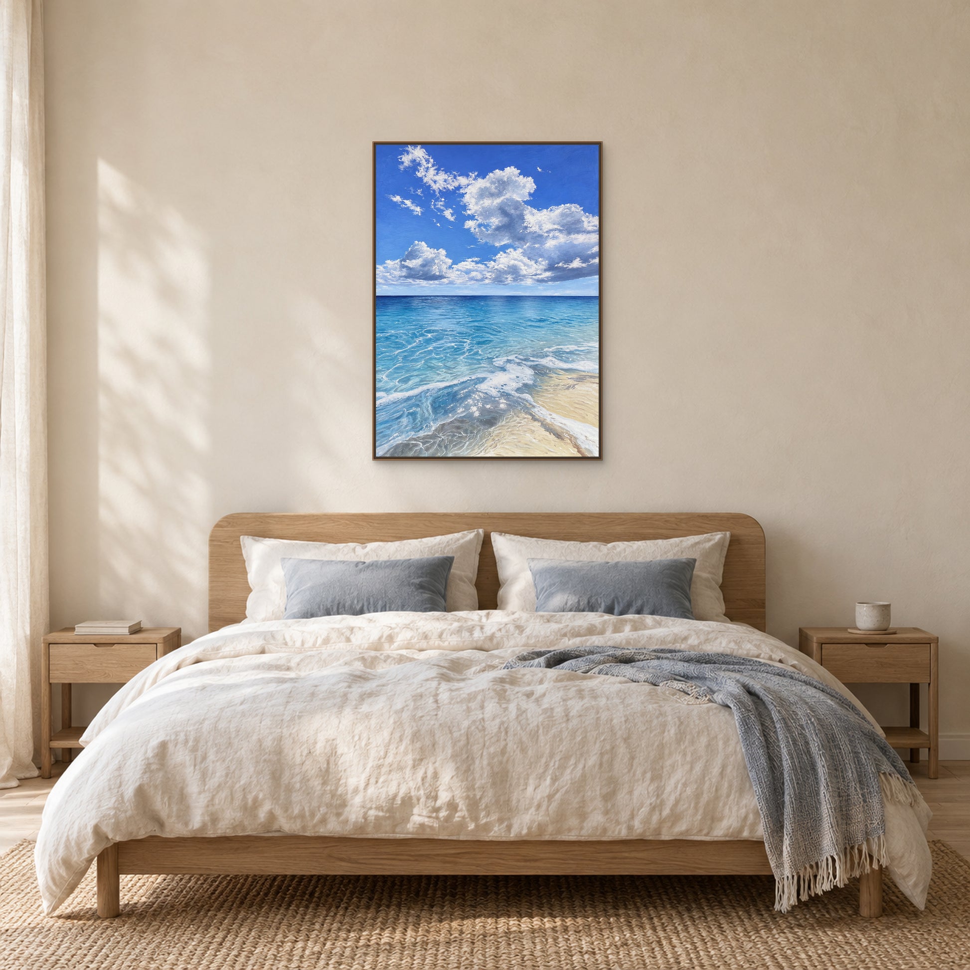 Vertical blue seascape in a wood-tone floating frame centred above an oak headboard and ivory bedding