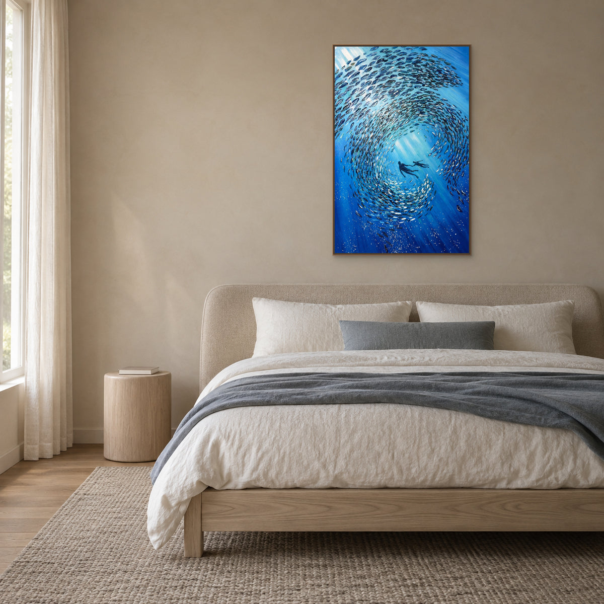 Blue underwater painting in an oak-toned floating frame centred above a rounded upholstered headboard and grey bedding