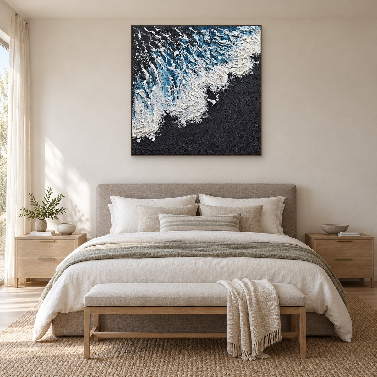 Blue and white surf on a charcoal ground in an oak-tone frame above a grey upholstered bed
