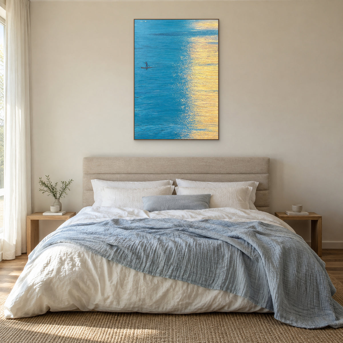 Blue and gold water painting in an oak-tone frame centred above a linen bed