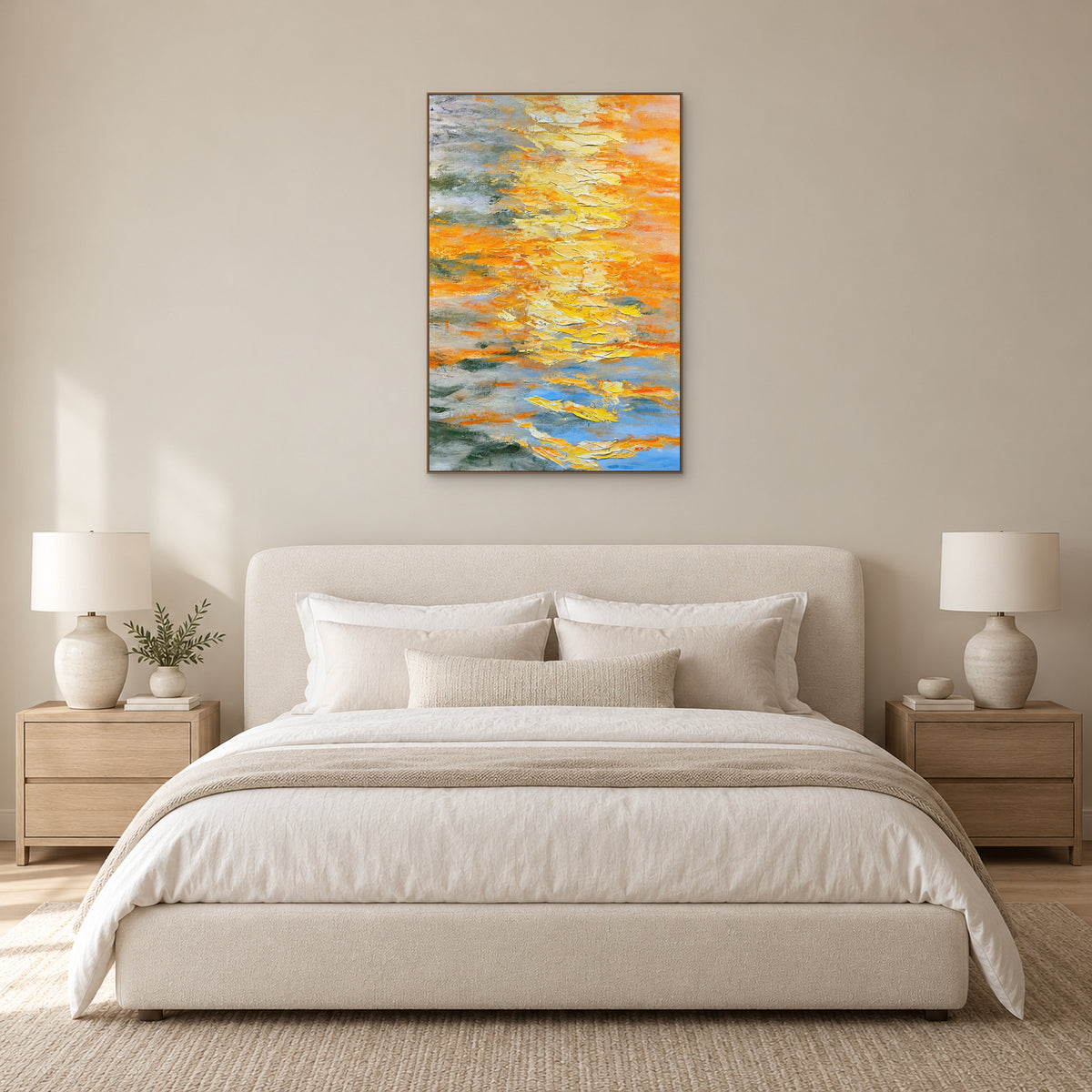 Yellow abstract painting in an oak-toned frame centred above a cream upholstered bed with matching bedside lamps
