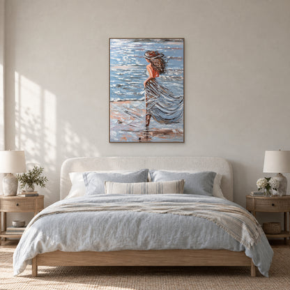 Coastal woman painting in an oak-toned floating frame centred above a rounded ivory headboard with pale blue bedding