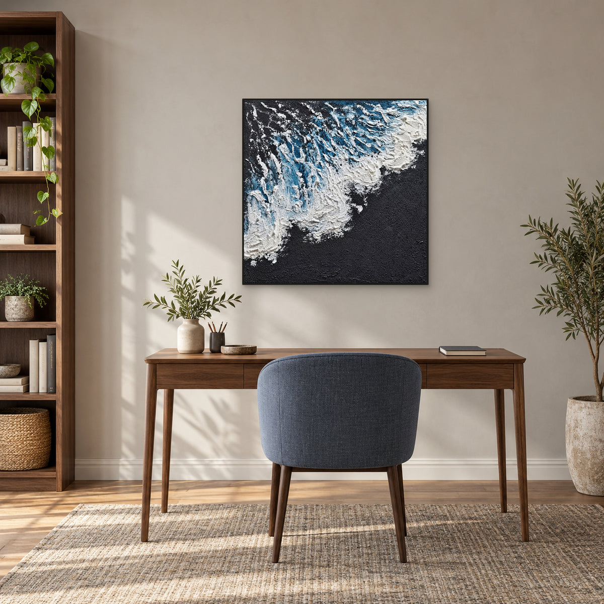 Square wave painting in a black frame centred above a walnut desk and a slate-blue chair