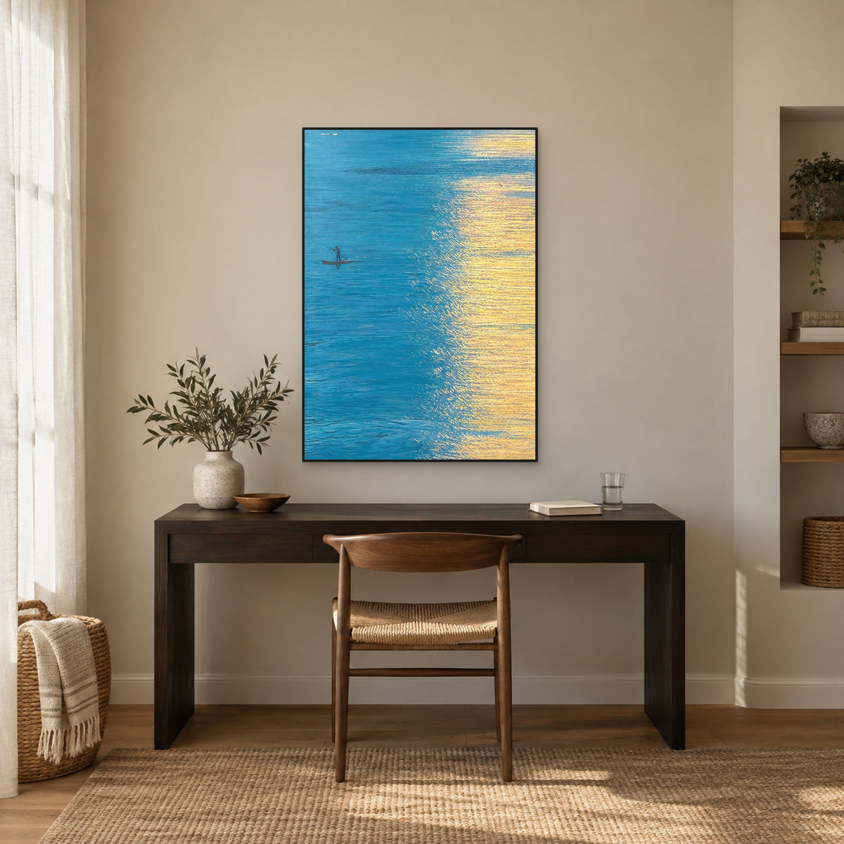 Turquoise seascape with a tiny boat in a black floating frame above a dark writing desk