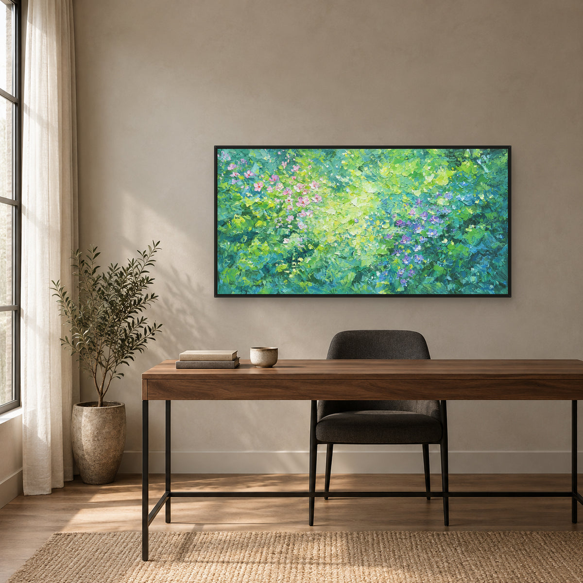 Pink and violet flowers on green in a black floating frame above a walnut desk and charcoal chair beside a window