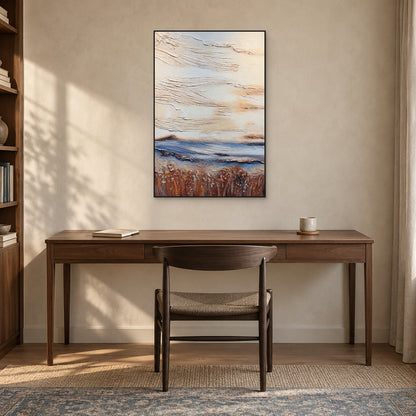 Tall textured abstract in a thin black frame above a dark wooden desk and woven-seat chair