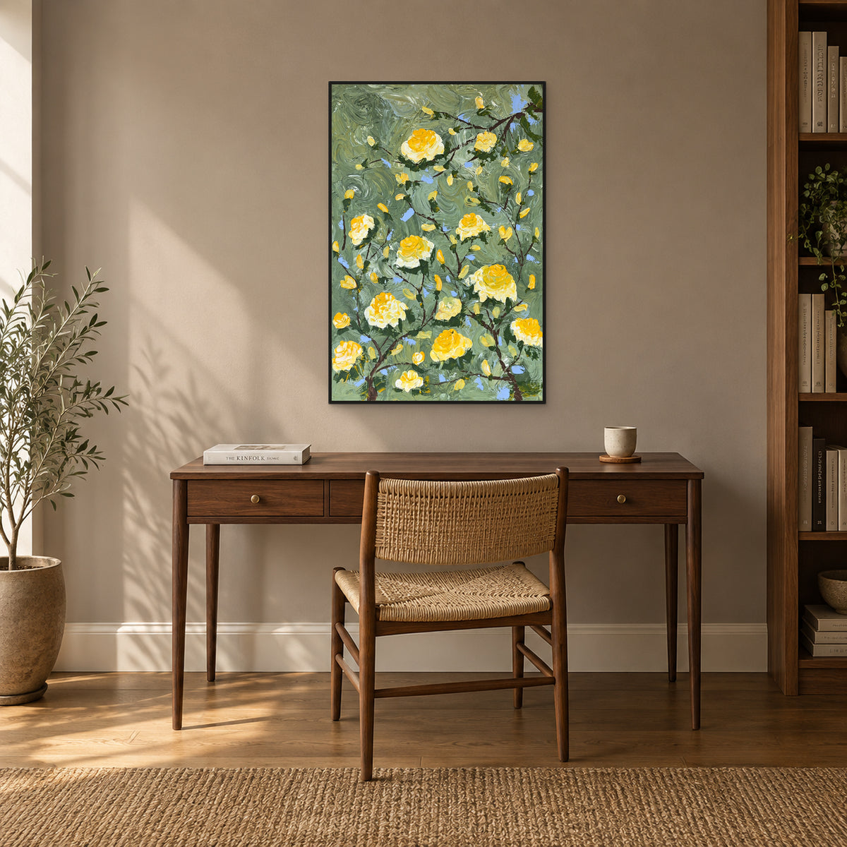 Sage-green and yellow floral painting in a black floating frame above a walnut writing desk