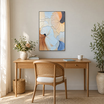 Pastel relief painting in a thin black frame above an oak desk and cane-backed chair, with flowers to the left