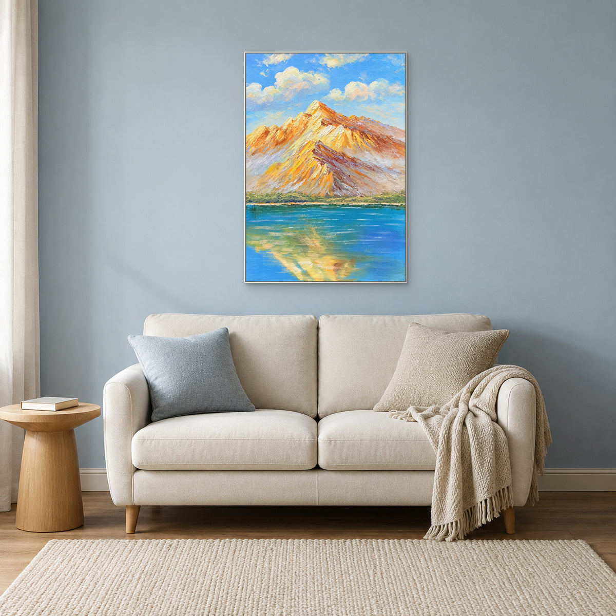 White-framed mountain reflection painting above a cream loveseat against a muted blue wall