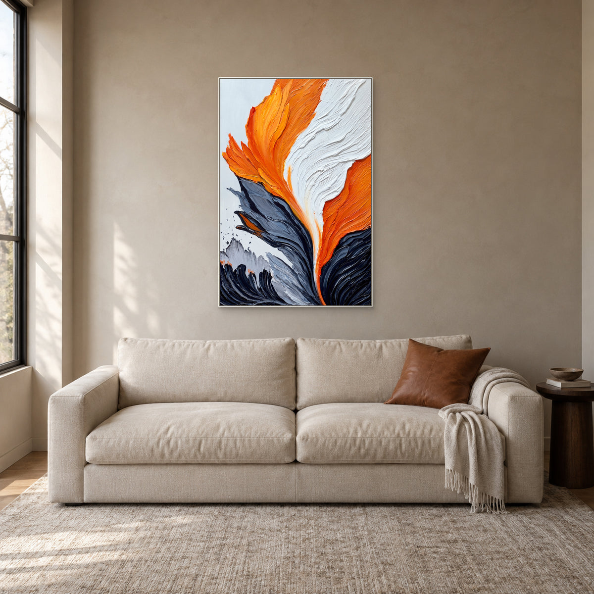 Textured orange and white abstract painting in a thin white frame above a cream sofa in a reading nook