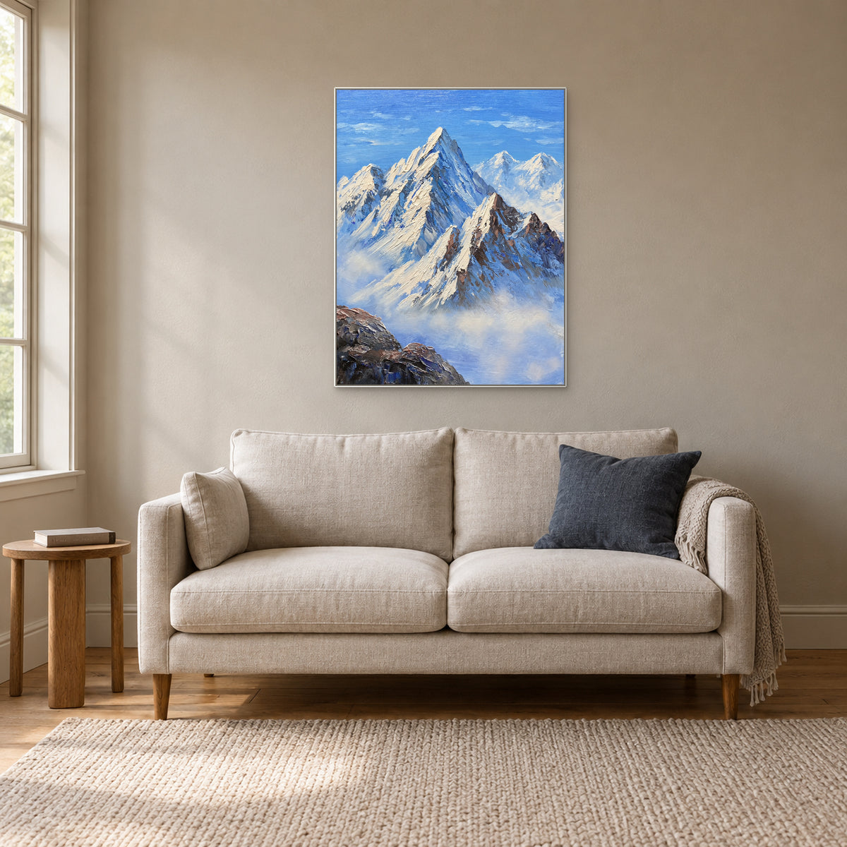 Vertical mountain artwork in a white frame above a cream sofa in a reading room
