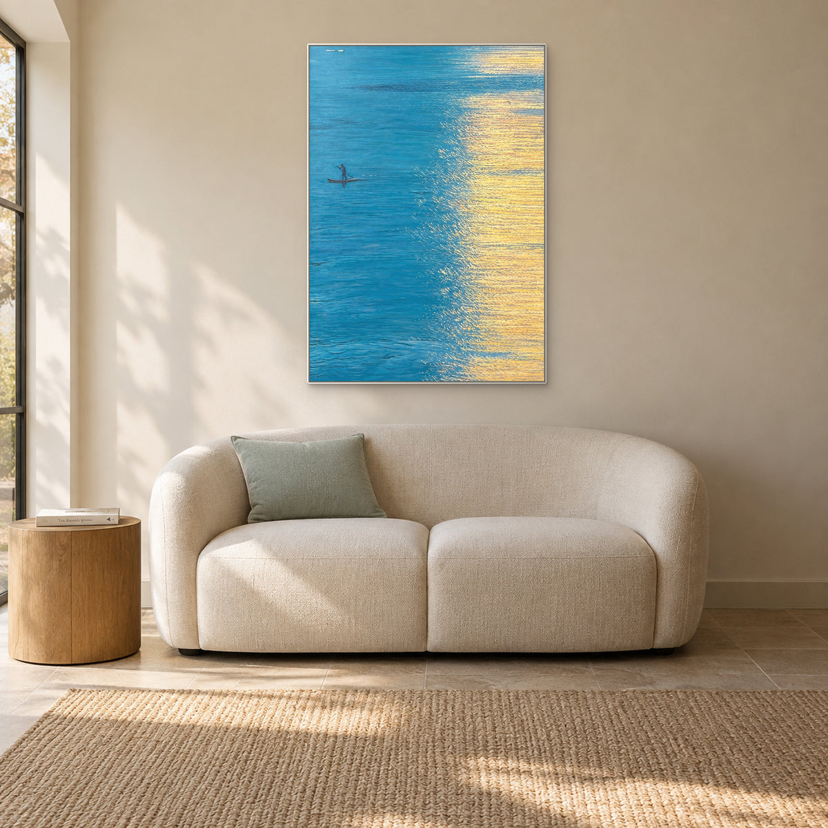 Golden Water in a thin white frame above a cream reading sofa
