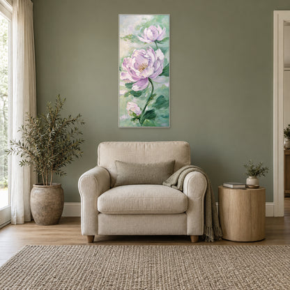 Tall lilac peony painting in a white floating frame centred above a cream armchair against a sage wall