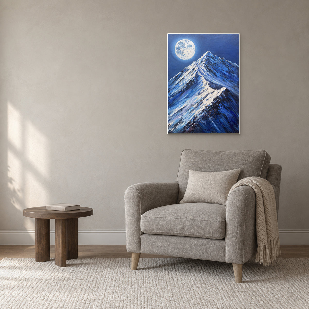 Blue nocturnal mountain artwork in a white frame above a grey reading armchair
