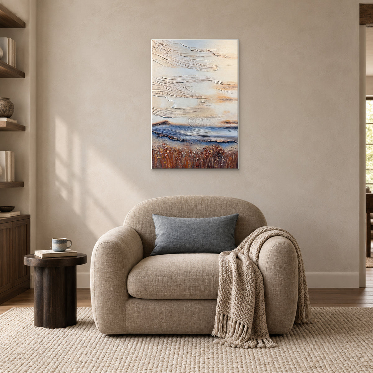 Ivory and rust-brown abstract with a blue band in a white frame above a beige reading chair