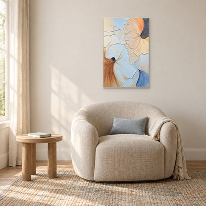 Pale-blue and cream abstract in a white frame above a rounded cream reading chair beside a window