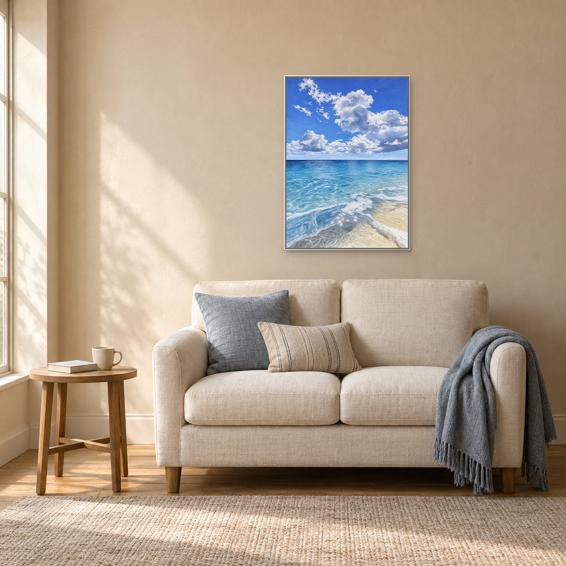Turquoise seascape in a white floating frame above an ivory loveseat beside a small oak table