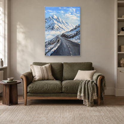 Blue and white mountain landscape in a white floating frame above an olive-green reading sofa