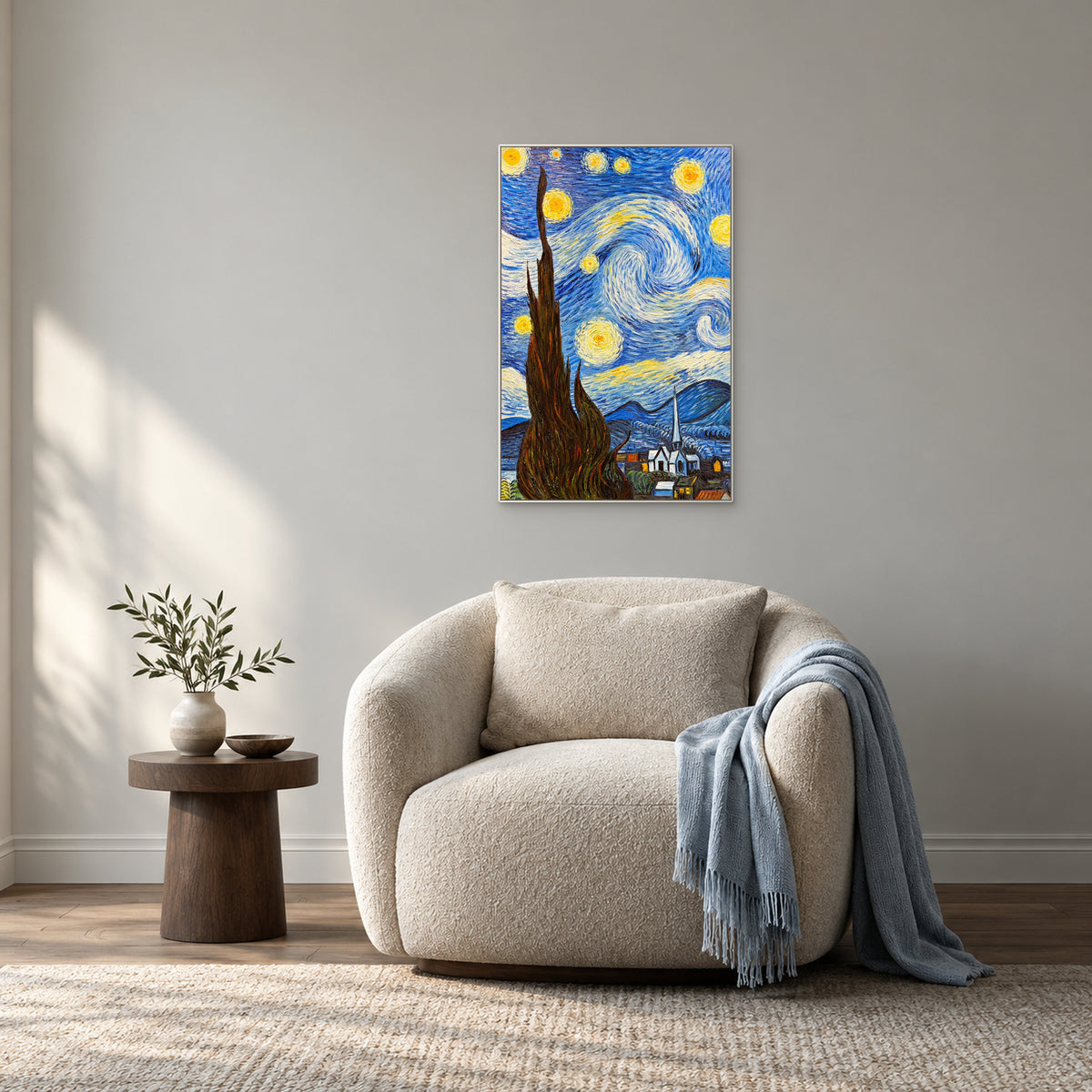 Starry cypress painting in a white frame above an oatmeal armchair with a pale blue throw