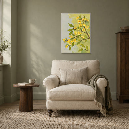White-framed yellow blossom painting on a muted green wall above a cream reading chair