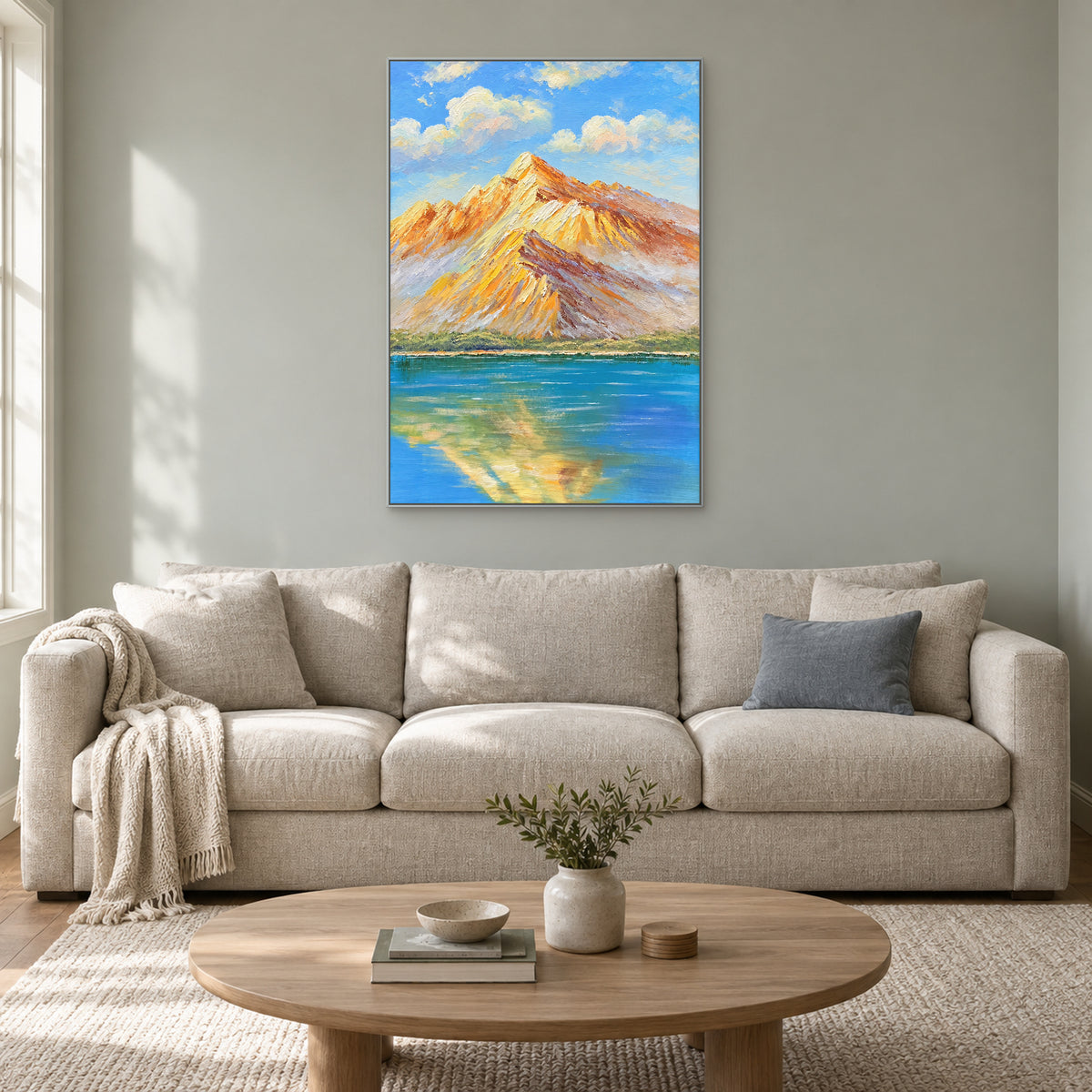 Vertical amber mountain landscape in a silver-tone frame over an oatmeal sofa on a sage-grey wall