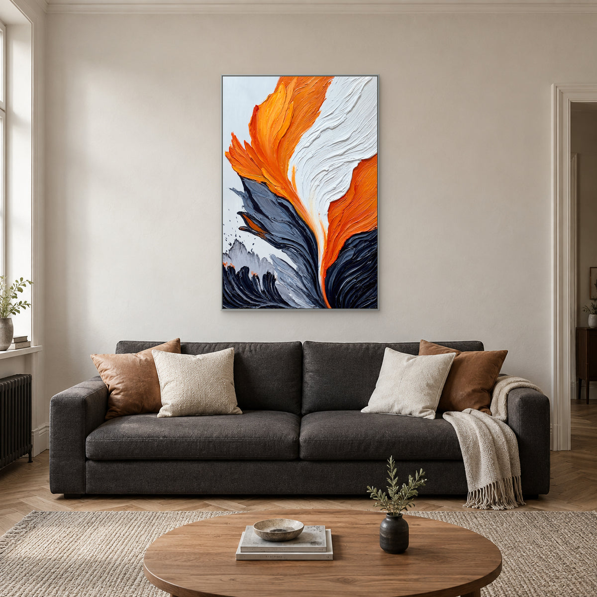 Vertical orange, white and grey painting in a silver-tone frame centred above a charcoal sofa