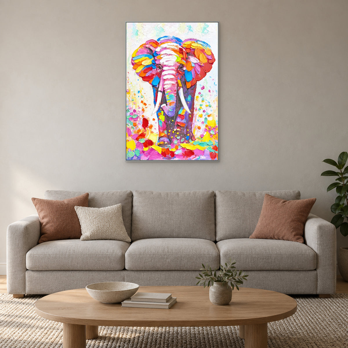 Colourful elephant in a silver-tone frame above a pale sofa with terracotta cushions