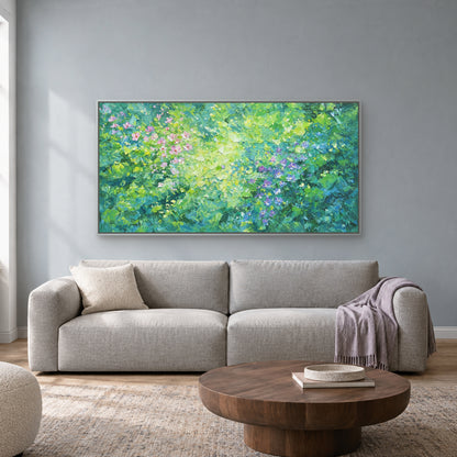 Horizontal green floral painting in a silver-toned floating frame above a pale grey sofa against a blue-grey wall