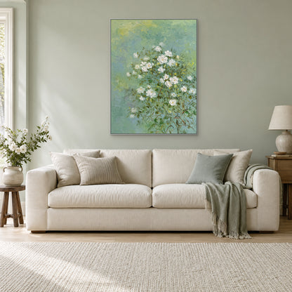 Textured jasmine floral painting in a silver-tone frame above an ivory sofa on a pale sage wall
