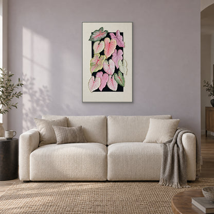Textured caladium leaf composition in a silver-tone floating frame above a cream sofa on a pale lavender-grey wall