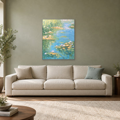 Vertical blue-green pond artwork in a silver-look floating frame above a cream sofa on a sage wall