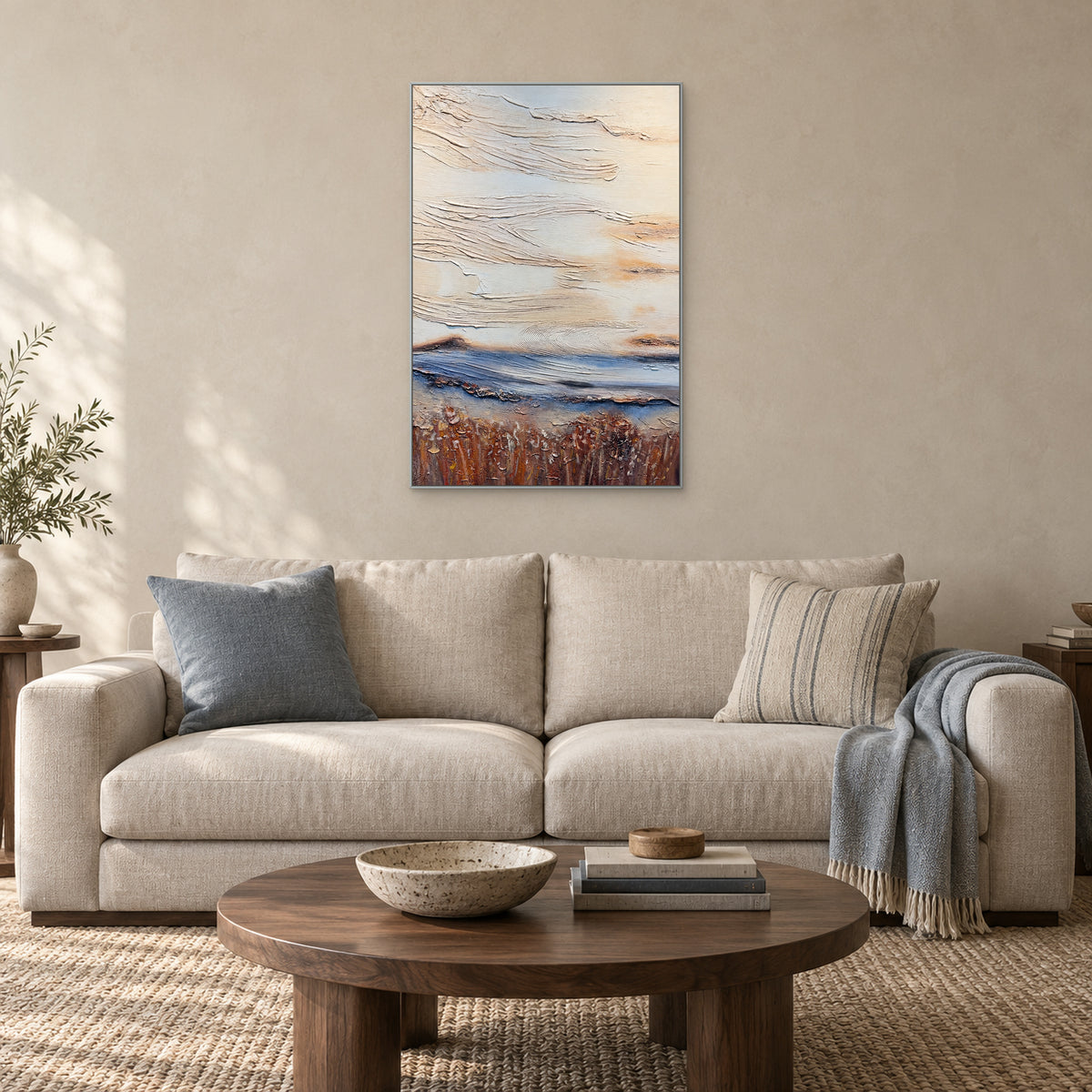 Pale textured abstract in a silver-coloured frame above an ivory sofa with dusty-blue cushions