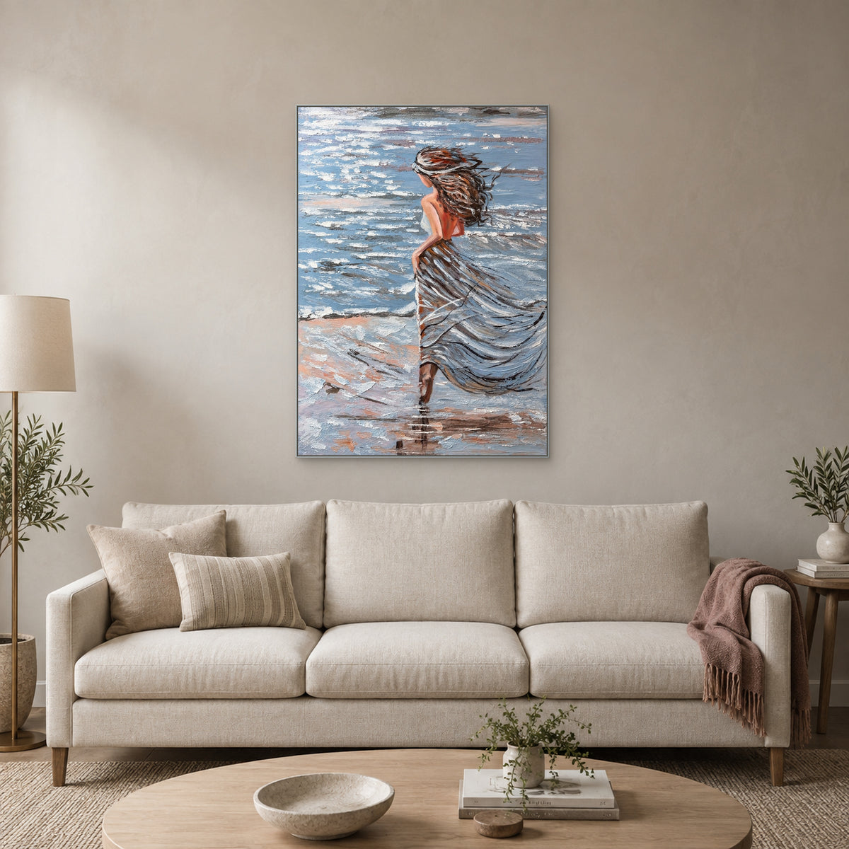 Sea Breeze painting in a silver-toned floating frame centred above an ivory sofa with a dusty-pink throw
