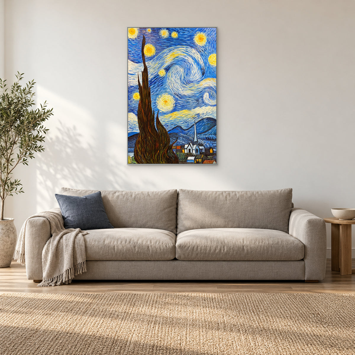Tall cypress and swirling night sky in a silver-tone frame above a light sofa with a blue cushion