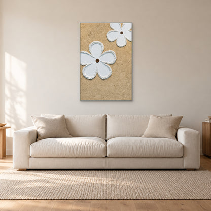 Vertical white flower relief in a slim silver-coloured frame above an off-white sofa