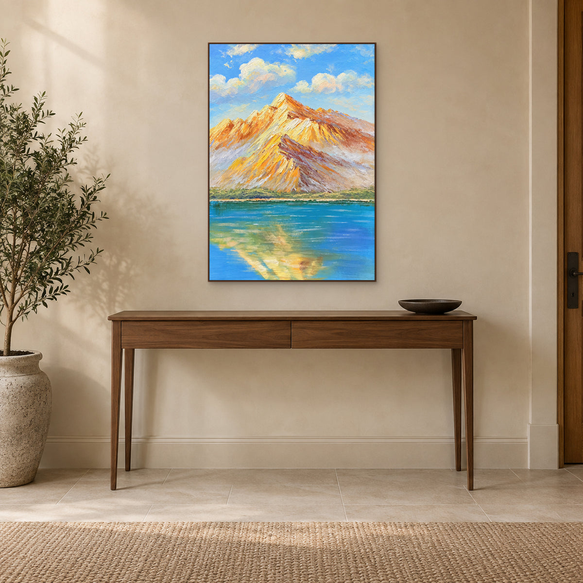 Mountain lake painting in a walnut-tone frame above a slim wooden entryway console