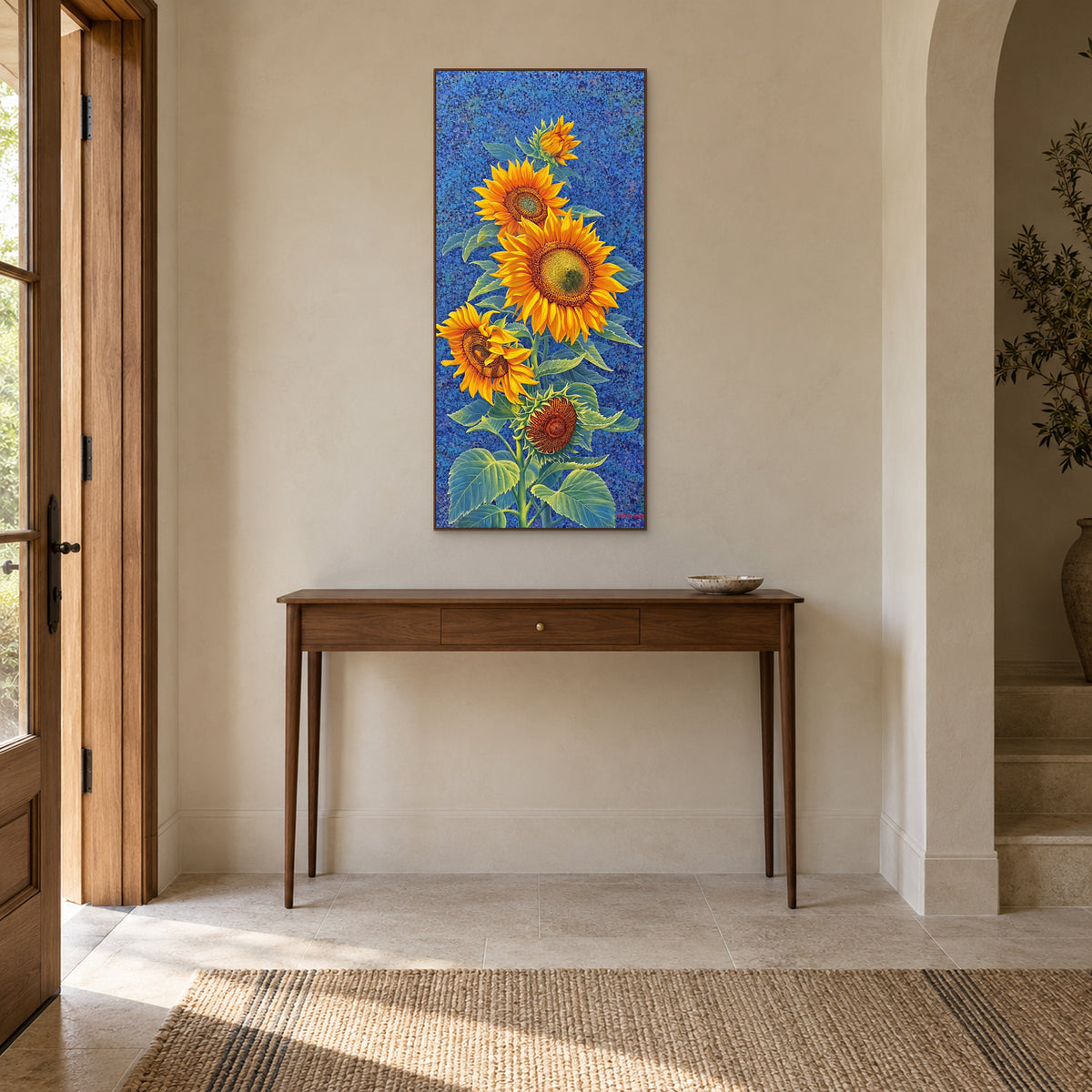 Sunflower painting in a walnut-tone frame above a slender console in a softly lit entryway