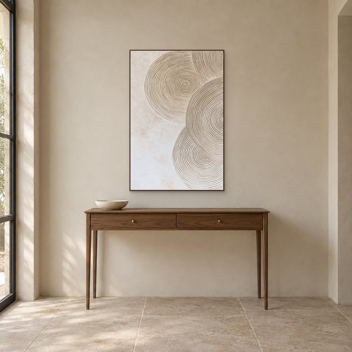 Sand and ivory concentric circles in a walnut-look frame above a slim wooden entryway console.